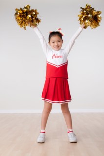 Studio portrait of girl (8-9) cheerleading. Photo : Rob Lewine