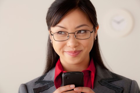 Studio portrait of businesswoman text-messaging. Photo : Rob Lewine