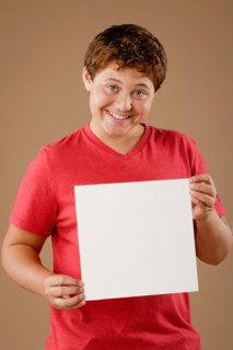 Studio portrait of boy (12-13) holding blank sheet of paper. Photo : Rob Lewine