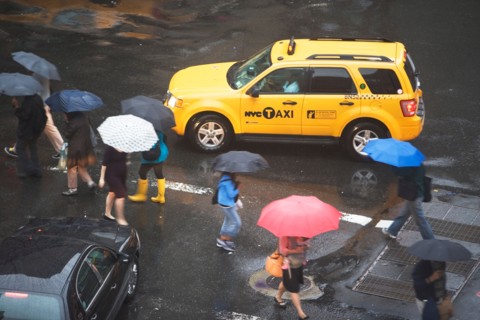 USA, New York State, New York City, Manhattan, Yellow taxi cab on street, pedestrians walking with