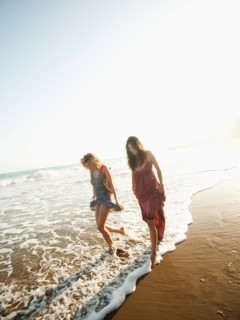 Attractive young woman walking on sandy beach.