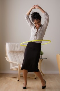 Young businesswoman using hoola hoop. Photo : Rob Lewine