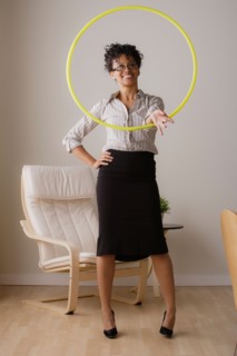 Young businesswoman using hoola hoop. Photo : Rob Lewine