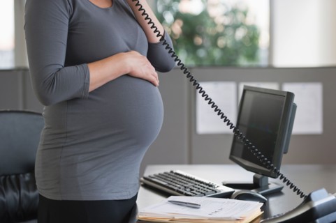 Young pregnant woman working in office.