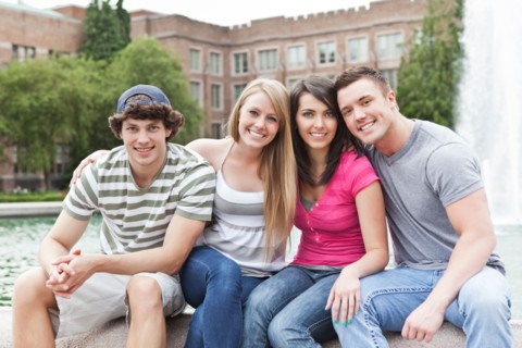 Portrait of two couples sitting at fountain. Photo: Take A Pix Media