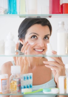 Woman applying lotion on face. Photo: Jamie Grill