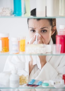 Woman sneezing and using tissue. Photo : Jamie Grill