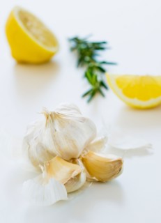 Studio shot of fresh garlic lemon and rosemary.