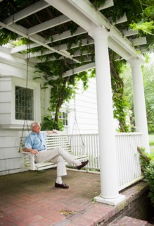 Senior man sitting on porch swing.