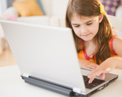 Girl ( 6-7) using laptop. Photo : Jamie Grill