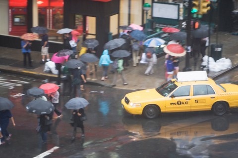 USA, New York State, New York City, Manhattan, Yellow taxi cab on street, pedestrians walking with