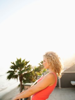 Young attractive woman contemplating seascape from terrace.