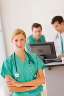 Portrait of female doctor in front of nurse's station.
