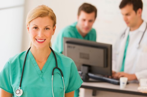 Portrait of female doctor in front of nurse's station.