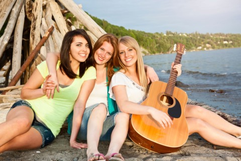 Portrait of three young women hanging out on beach. Photo : Take A Pix Media