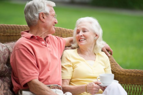 Senior couple relaxing on outdoor sofa.