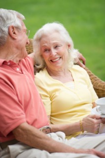 Senior couple relaxing on outdoor sofa.