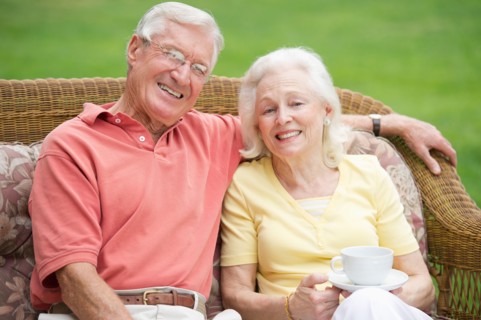 Senior couple relaxing on outdoor sofa.