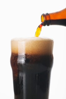 Ale pouring into glass, studio shot.