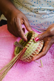 USA, South Carolina, Charleston, Close up of woman's hand weaving sweetgrass basket.
