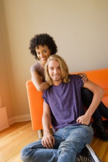 Portrait of young couple in living room. Photo : Rob Lewine
