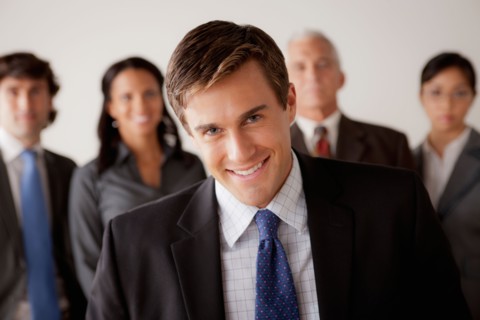 Studio shot of business people, focus on young business man. Photo : Rob Lewine