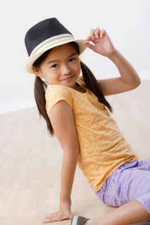 Studio portrait of girl (8-9) wearing hat. Photo : Rob Lewine