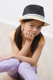 Studio portrait of girl (8-9) wearing hat. Photo: Rob Lewine