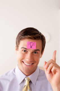 Portrait of businessman with adhesive note attached on forehead. Photo : Rob Lewine