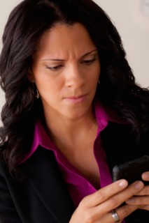 Studio portrait of businesswoman text-messaging. Photo : Rob Lewine