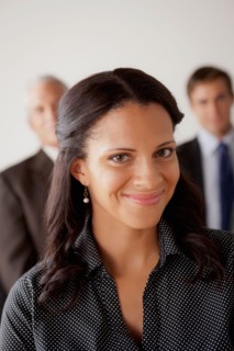 Studio shot of business people, focus on mid adult business woman. Photo : Rob Lewine