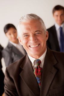 Studio shot of business people, focus on senior business man. Photo : Rob Lewine