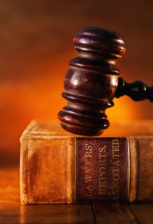 Close-up of gavel on lawyer book.