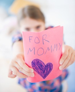 Girl ( 6-7) showing greeting card for mother's day. Photo : Jamie Grill