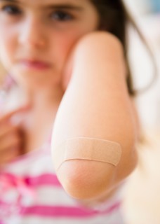 Girl ( 6-7) showing elbow with adhesive bandage. Photo : Jamie Grill