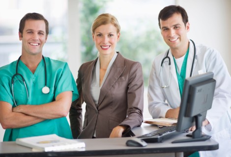Portrait of doctors and businesswoman at nurse's station.