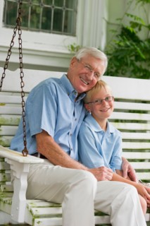 Grandfather and grandson (10-11) sitting on porch swing.