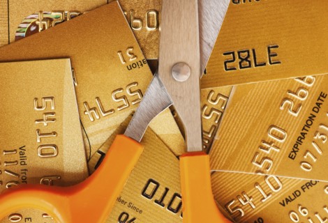 Scissors on pile of credit cards, studio shot.