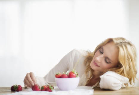 Woman eating strawberries, studio shot.