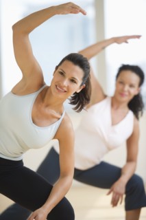 Two women exercising in gym.
