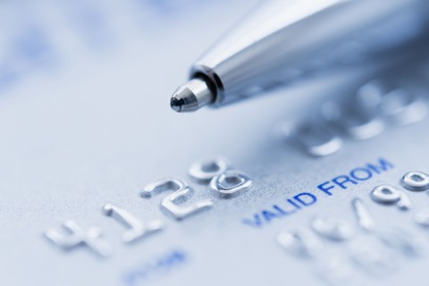 Detail of credit card with ballpoint pen, studio shot.