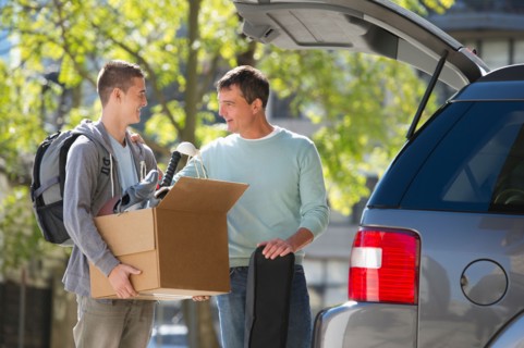 Father helping teenage son (16-17) packing to college.
