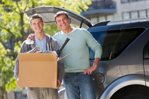 Father helping teenage son (16-17) packing to college.