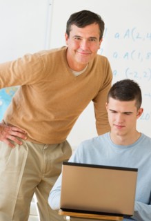 Teacher helping teenage (16-17) student .