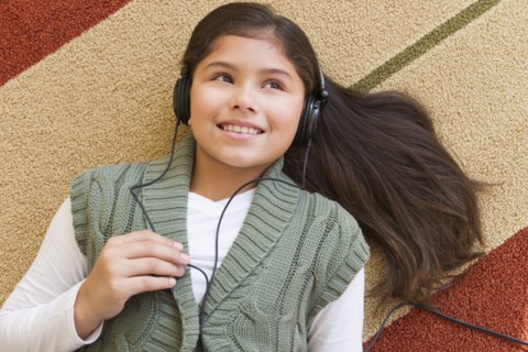 Girl (10-11) listening music .