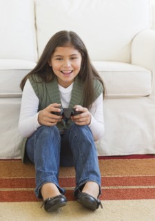 Girl (10-11) playing video games.