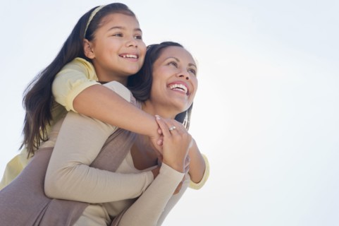 Mother giving piggyback ride to her daughter (10-11).