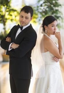 Bride and groom looking nervous standing back to back.