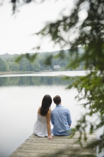 USA, New York, Putnam Valley, Roaring Brook Lake, Couple sitting on pier by lake. Photo: Jamie