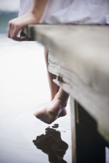Roaring Brook Lake, Close up of legs of woman sitting on pier by lake. Photo: Jamie Grill